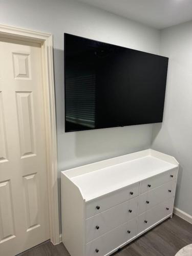 a white dresser with a flat screen tv on a wall at Spacious 1 Bdrm Studio Montrose in Houston