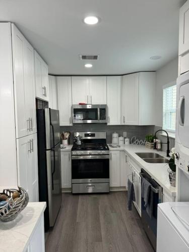 a kitchen with stainless steel appliances and white cabinets at Spacious 1 Bdrm Studio Montrose in Houston