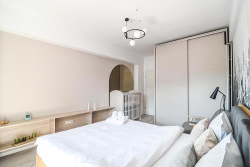 a bedroom with a white bed and a couch at Forest View Hideaway in Braşov