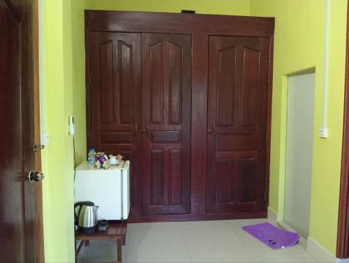 a large wooden door in a room with a refrigerator at Angkor Sandra Villa in Siem Reap