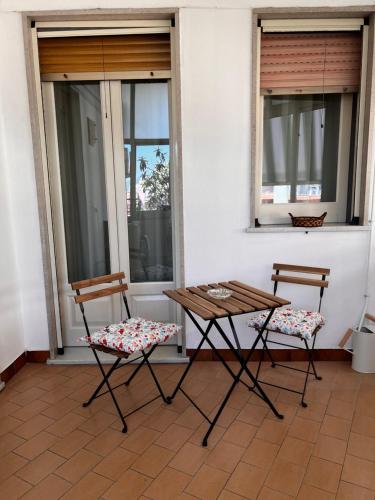 two chairs and a table on a porch with windows at Grandmas holiday home Sicily in Giarre