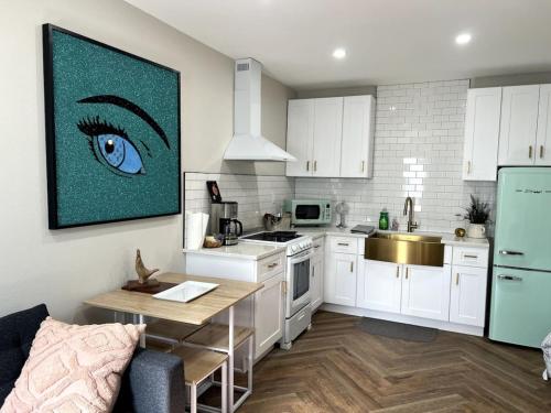 a kitchen with white cabinets and a blue eye on the wall at Downtown Groovy Studio in Orlando