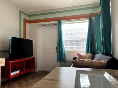 a living room with a couch and a television at Downtown Groovy Studio in Orlando