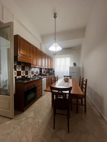 a kitchen with a table and chairs and a kitchen with a refrigerator at Grandmas holiday home Sicily in Giarre