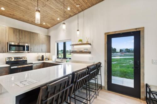 a kitchen with a large white counter and chairs at Mara Luxury Cabins- Ponderosa in Hamilton