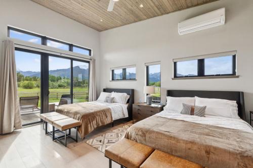 two beds in a room with a window at Mara Luxury Cabins- Ponderosa in Hamilton