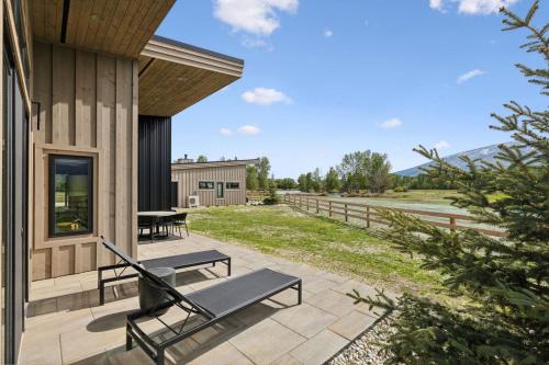 a patio with benches on the side of a building at Mara Luxury Cabins- Ponderosa in Hamilton