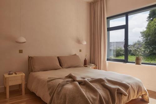 une chambre avec un lit avec une grande fenêtre dans l'établissement Yarn - Romy Deluxe Apartment, à Ballycastle