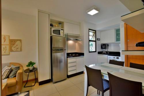 a kitchen with a stainless steel refrigerator and a table at BSB STAY Flats Particulares - Life Resort SHTN in Brasilia