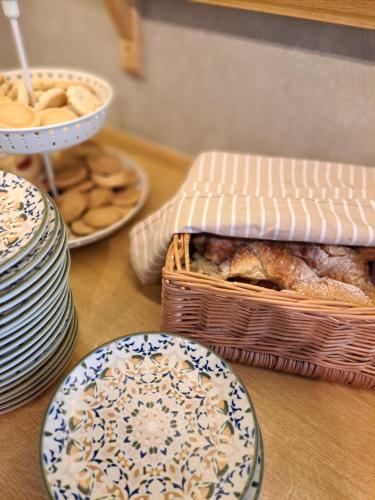 a table topped with plates and a basket of food at Hotell Rådhuset in Lidköping