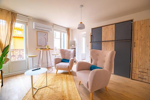 un salon avec deux chaises et une table dans l'établissement Les suites du palais des expositions, à Perpignan