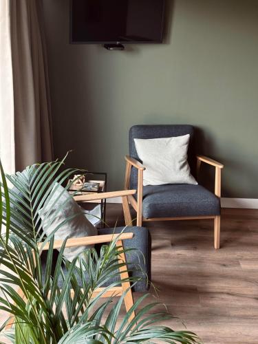 a living room with a chair and a table at Boerderijkamers Sniedershof in Deurningen