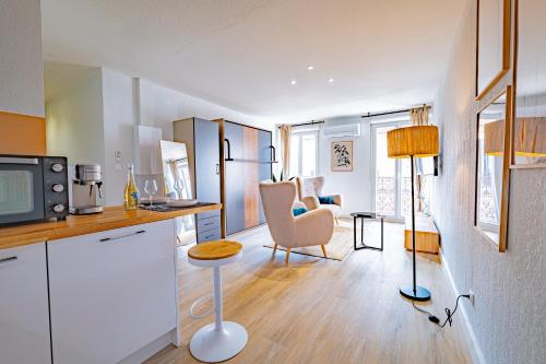 Il comprend une cuisine et un salon avec une table et un four micro-ondes. dans l'établissement Les suites du palais des expositions, à Perpignan