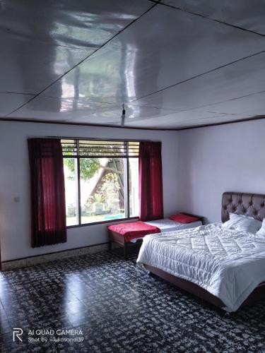 a bedroom with a large bed and a window at Bernard's Guest Houses in Tuktuk Siadong