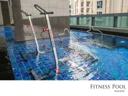 a swimming pool with two poles in the water at The Sweet Escape 1 BR w Pool, Sauna, Gym and More in Manila