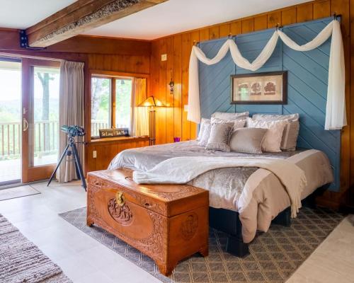 Un dormitorio con una cama con una pared azul. en Dragonwood Main House, en Abbot Village