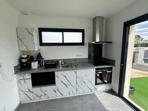 d'une cuisine avec un comptoir, un évier et une fenêtre. dans l'établissement House 60 with 3 bedrooms lechaffardcom, à Satolas-et-Bonce