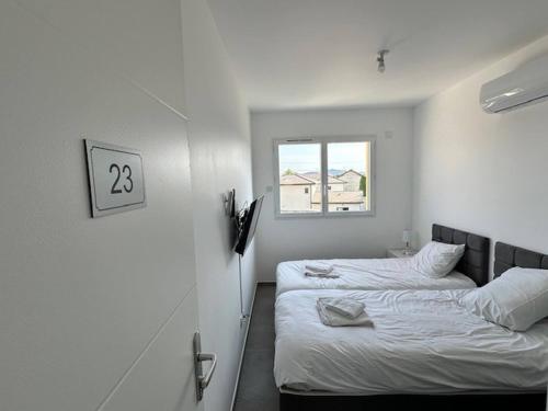deux lits dans une chambre blanche avec une fenêtre dans l'établissement House 20 with 5 bedrooms lechaffardcom, à Satolas-et-Bonce