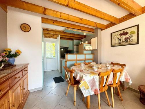 une salle à manger avec une table et une cuisine dans l'établissement Maison à Carnac: 2 Chambres, 4 Couchages, Jardin, Parking, Proche Plage et Commerces - FR-1-377-46, à Carnac