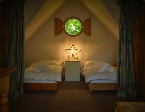 two twin beds in a room with a star on the wall at Lochend Chalets in Port of Menteith