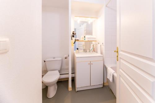 a white bathroom with a toilet and a sink at Cerise Valence in Valence