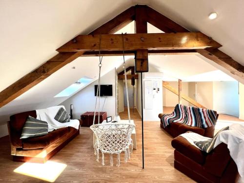 un salon avec une balançoire dans le grenier dans l'établissement 3 appartements réunis! Ascenseur Terrasse Vue, à Bagnères-de-Bigorre