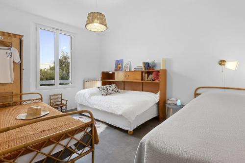une chambre avec deux lits et une fenêtre dans l'établissement Superbe 120m2, proche centre, parking, à Saint-Raphaël