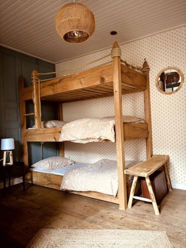 Ce dortoir comprend 2 lits superposés et un tabouret. dans l'établissement La Tour du Marché, à Allanche