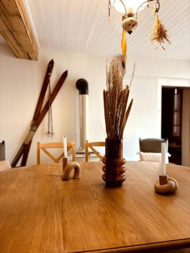 - une table en bois avec deux bougies et un vase dans l'établissement La Tour du Marché, à Allanche