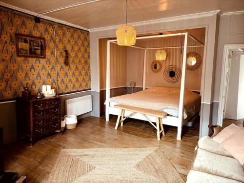 a bedroom with a canopy bed and a couch at La Tour du Marché in Allanche
