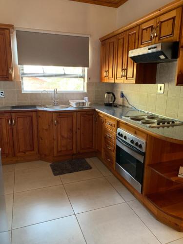 a kitchen with wooden cabinets and a stove top oven at At Rosies on Robin - Luxury & Comfort in Rustenburg