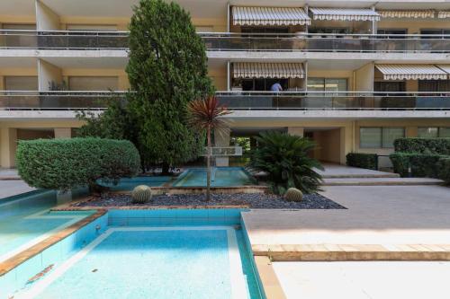 un immeuble d'appartements avec une piscine devant dans l'établissement Cosy Appartement, Centre-ville Cannes, Terrasse, Clim, à Cannes