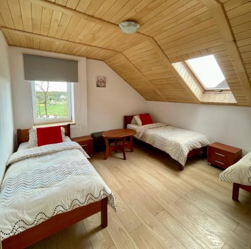 a attic room with two beds and a table at Agroturystyka Aksamitka in Lubiąż
