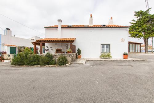 a white house with a driveway in front of it at Casa dos Relvas in Godigana