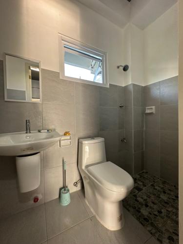 レガスピにあるCasita de Gloria Hometelのトイレ、洗面台、窓のあるバスルーム