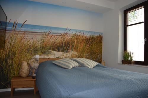 a bedroom with a bed and a painting of a beach at Ferienwohnung Schöne Zeit! 15204 in Leer