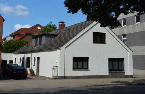 a white house with a black roof at Ferienwohnung Schöne Zeit! 15204 in Leer