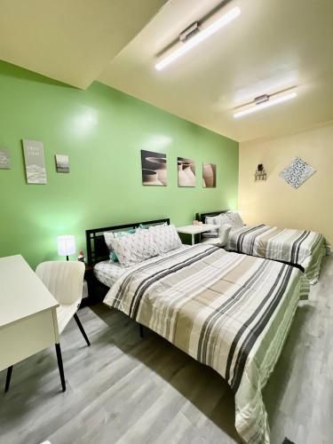 two beds in a room with green walls at Private Room Near Airport K6 in Mississauga