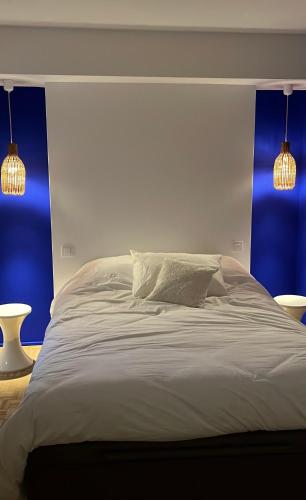 - une chambre avec un lit blanc aux murs bleus et deux lumières dans l'établissement Splendide penthouse au coeur de Nice, à Nice