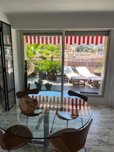 Cette chambre dispose d'une terrasse avec une table et des chaises en verre. dans l'établissement Splendide penthouse au coeur de Nice, à Nice