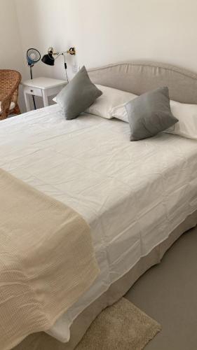 a large white bed with two pillows on it at Casa Veientana in Labaro