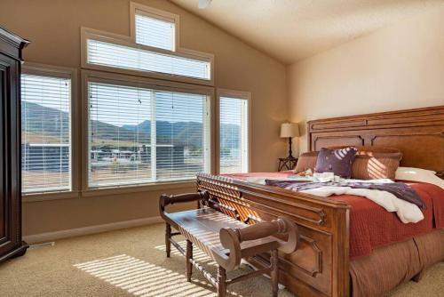 a bedroom with a bed with a bench and windows at Snowbasin Haven with Hot Tub and Resort Amenities in Huntsville