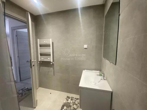 a bathroom with a toilet and a sink and a mirror at location saisonniere S1 a Hergla in Kasnadar