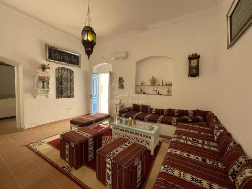 una sala de estar con un sofá y una mesa en location saisonniere Maison Traditionnelle a Monastir Medina, en Monastir