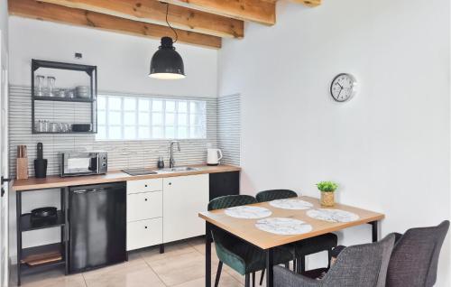 a kitchen with a table and chairs and a kitchen with a sink at 1 Bedroom Amazing Home In Podamirowo in Podamirowo
