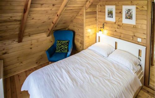 a bedroom with a white bed and a blue chair at 4 Bedroom Awesome Home In Vukovar in Vukovar