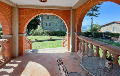 an outdoor patio with tables and chairs and a brick wall at Awesome Apartment In Castel Rigone in Castel Rigone