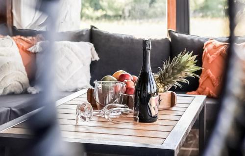 a table with a bottle of wine and a bowl of fruit at Stunning Home In Kostanjevac in Kostanjevac