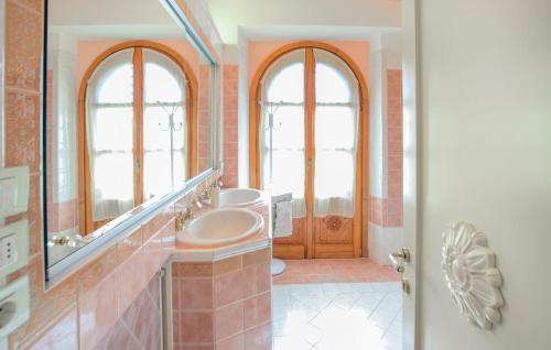 a bathroom with two windows and a sink and a mirror at Awesome Apartment In Castel Rigone in Castel Rigone
