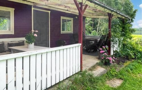 a porch of a house with a white fence at Nice Home In Stigtomta With Lake View in Stigtomta